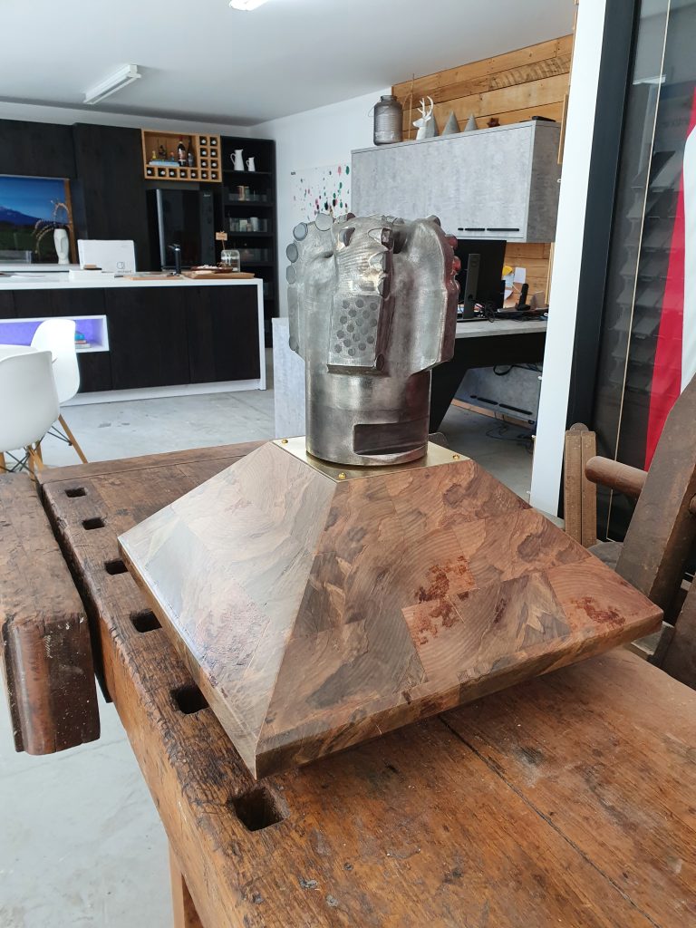 Handcrafted wooden display plinth with faceted timber base and mounted industrial drill bit, custom-made by Newton Gordge Joinery in Taranaki.