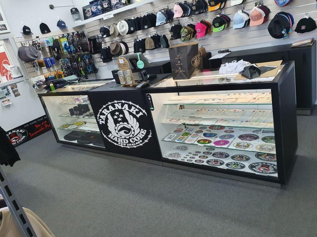 Custom retail display counter with black joinery, glass cabinets, and branded Taranaki Hardcore front panel designed and built by Newton Gordge Joinery.